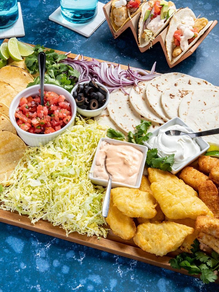 Fish taco toppings board with avocado and pico de gallo